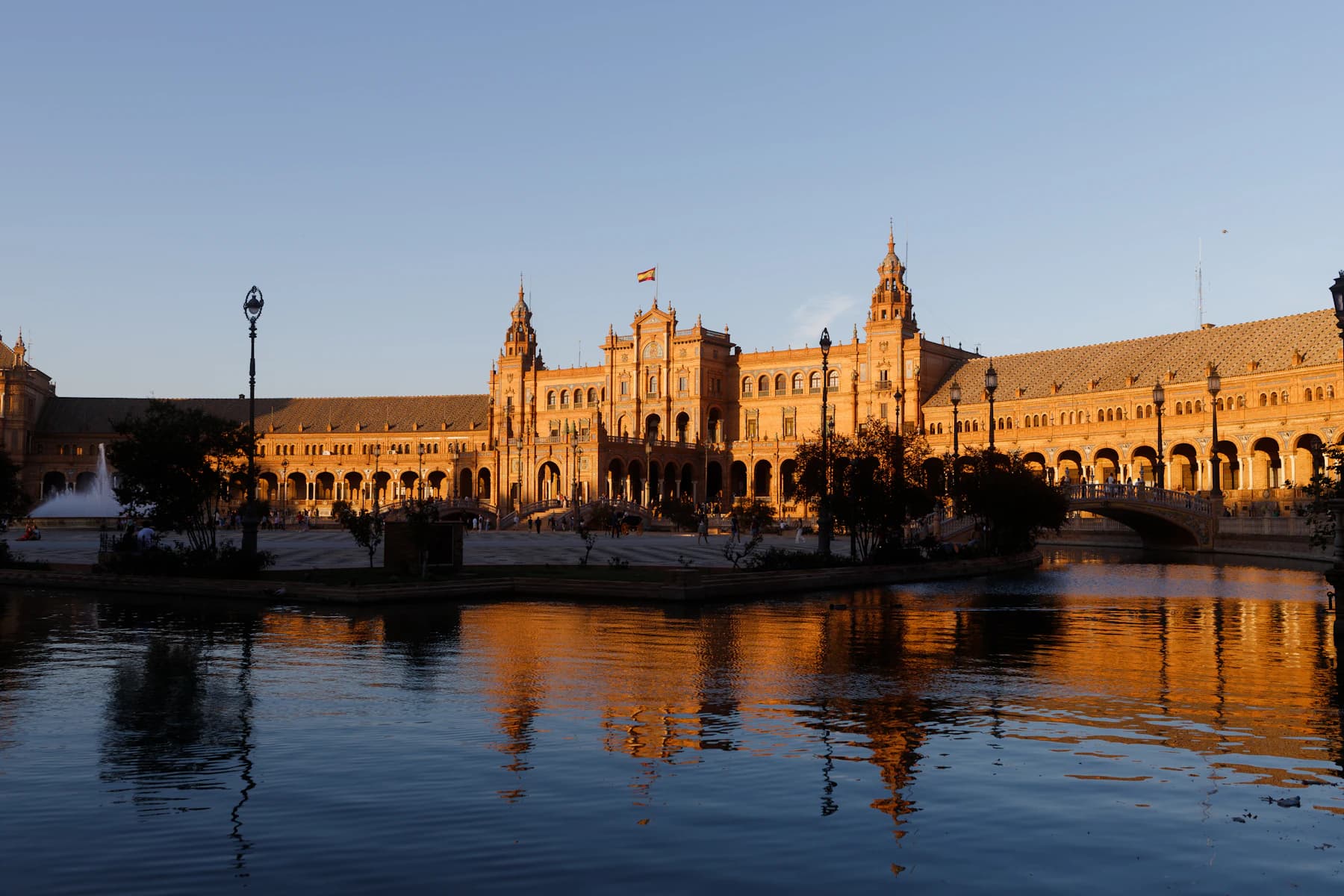 Plaza de España in Seville reflected in the water at sunset